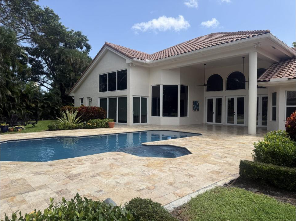 Travertine pool deck and pool at the rear of a Boca Raton estate — freshly pressure washed