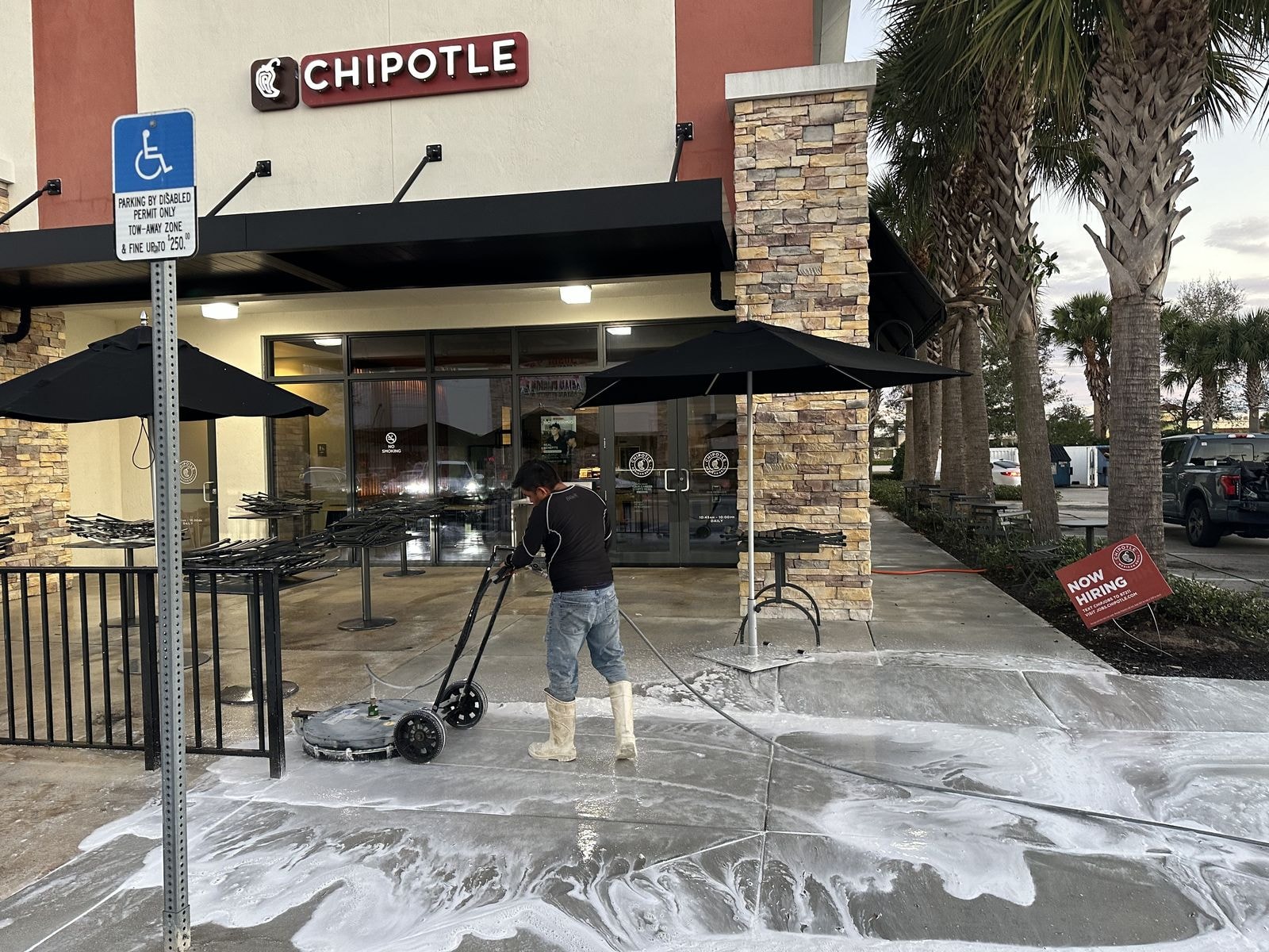 Commercial patio pressure washing with foam detergent applied mid-job in Boynton Beach, Florida