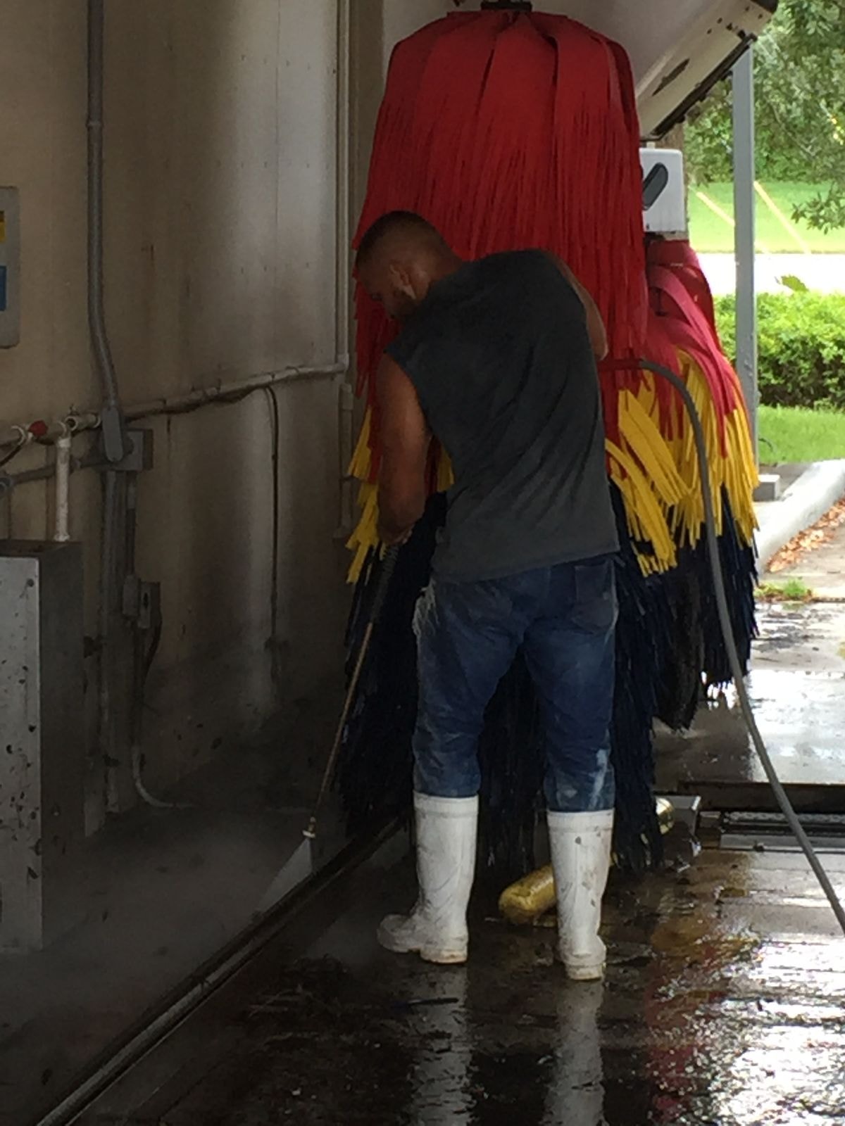 Close-up of car wash brush assembly being cleaned during commercial service in Coconut Creek, Florida