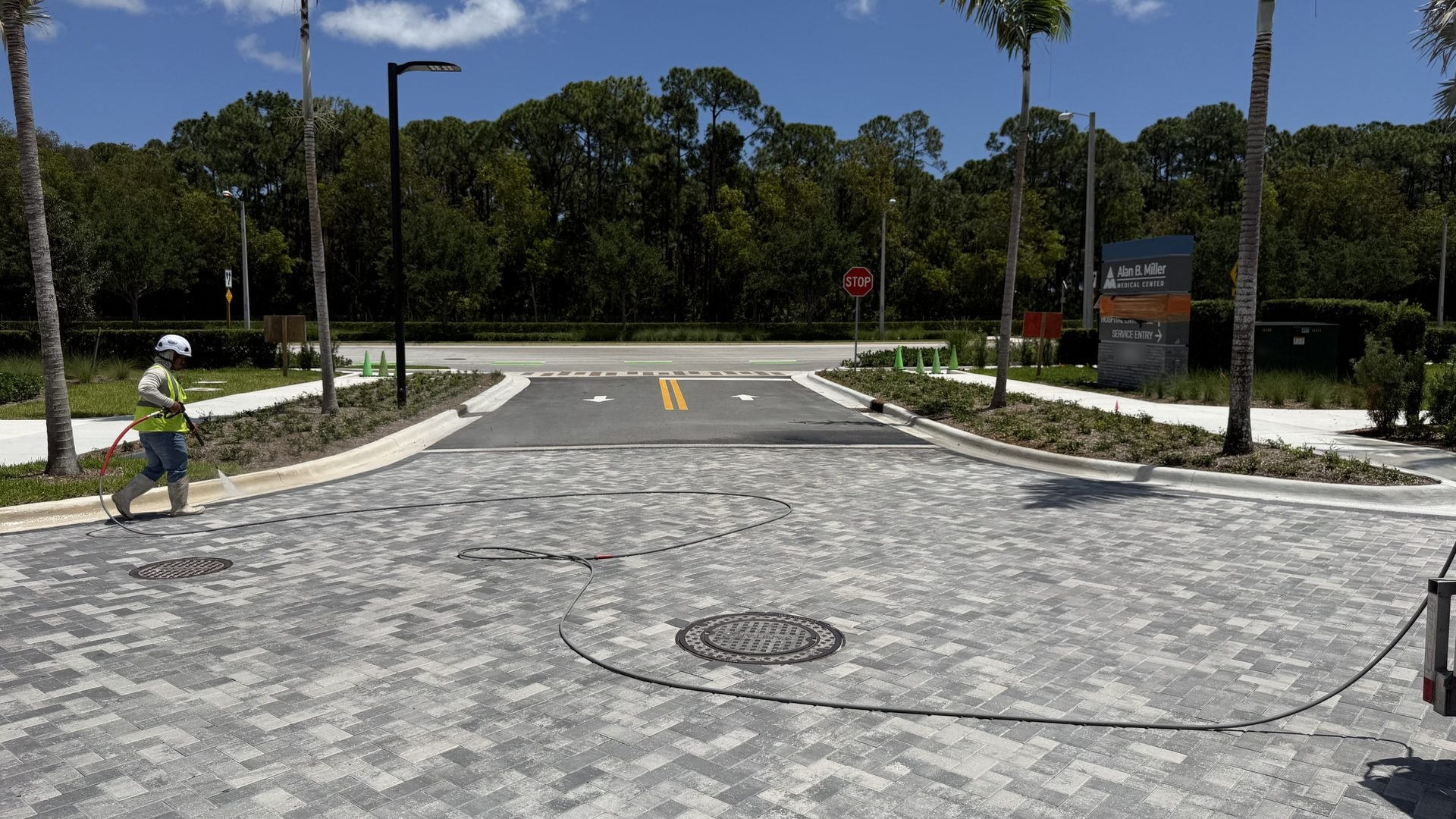 Crew pressure washing the paver entrance drive at a medical center, Palm Beach Gardens, FL