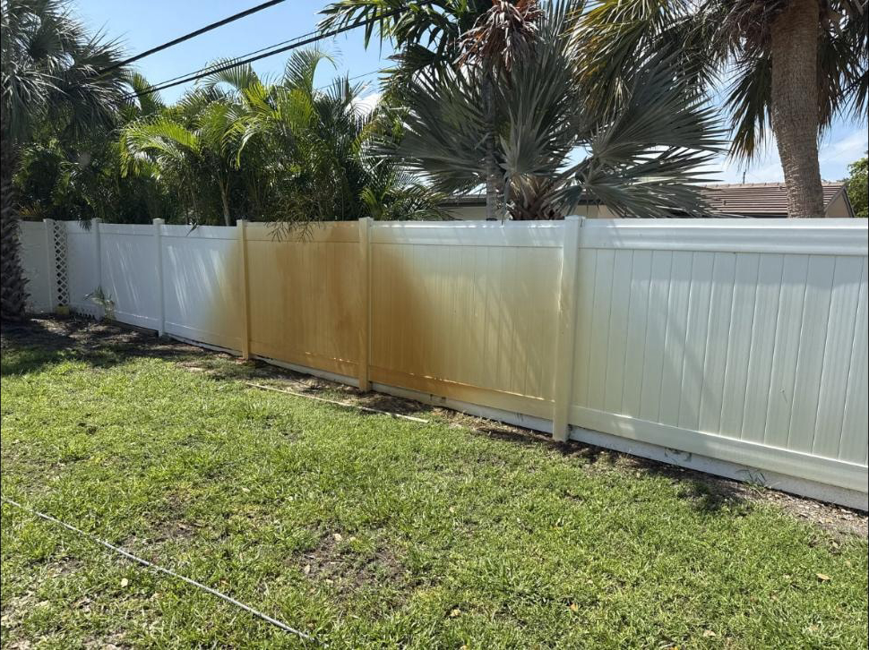 Before: Vinyl fence in Delray Beach, FL with heavy irrigation rust staining beside already-cleaned panels