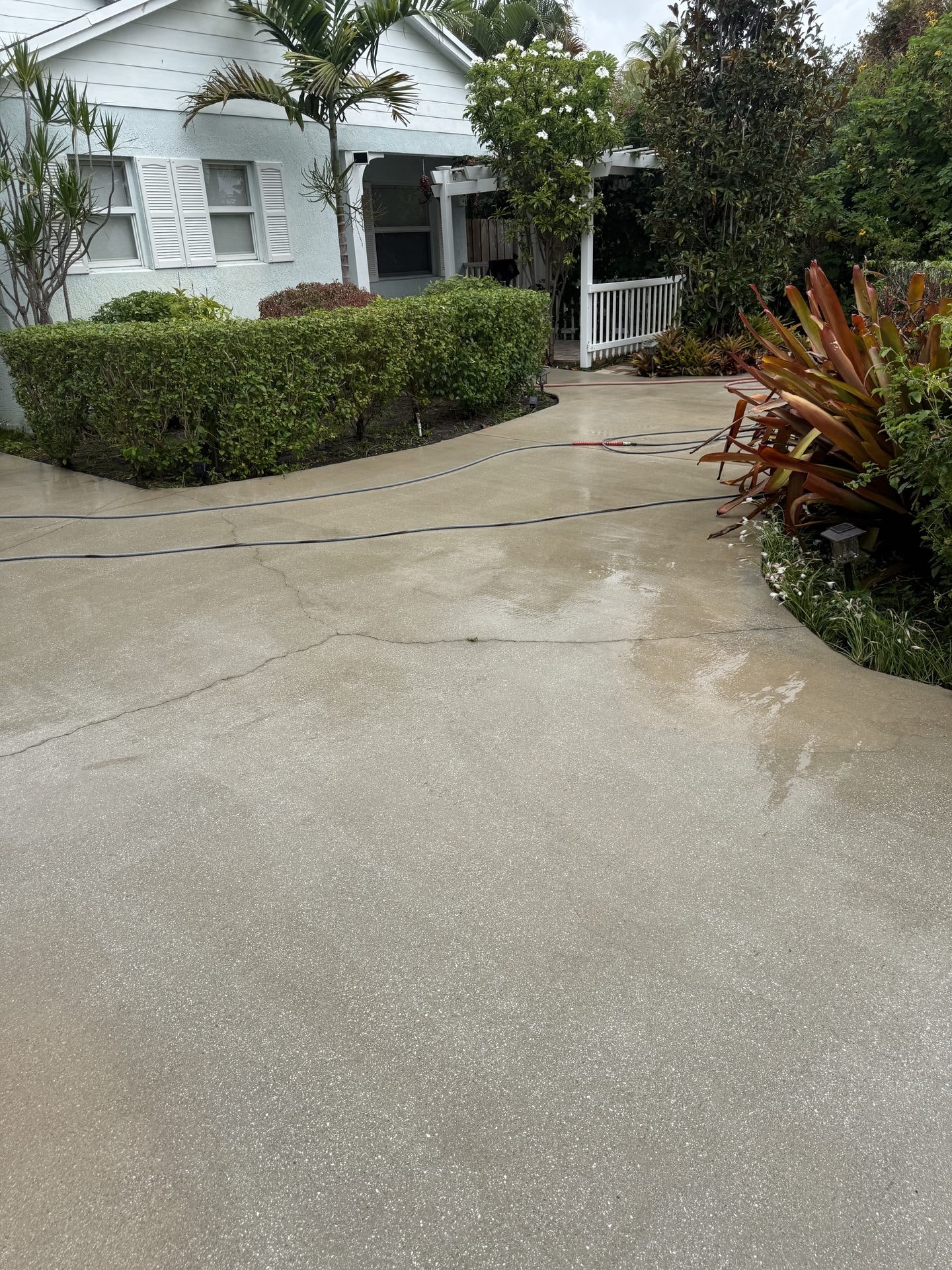After: The same concrete driveway after pressure washing with the concrete restored to clean pale grey, Boynton Beach, FL