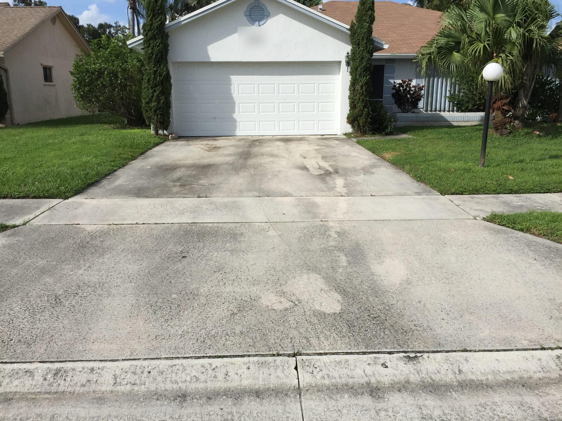 Concrete driveway with dirt and organic staining before cleaning, Greenacres, FL