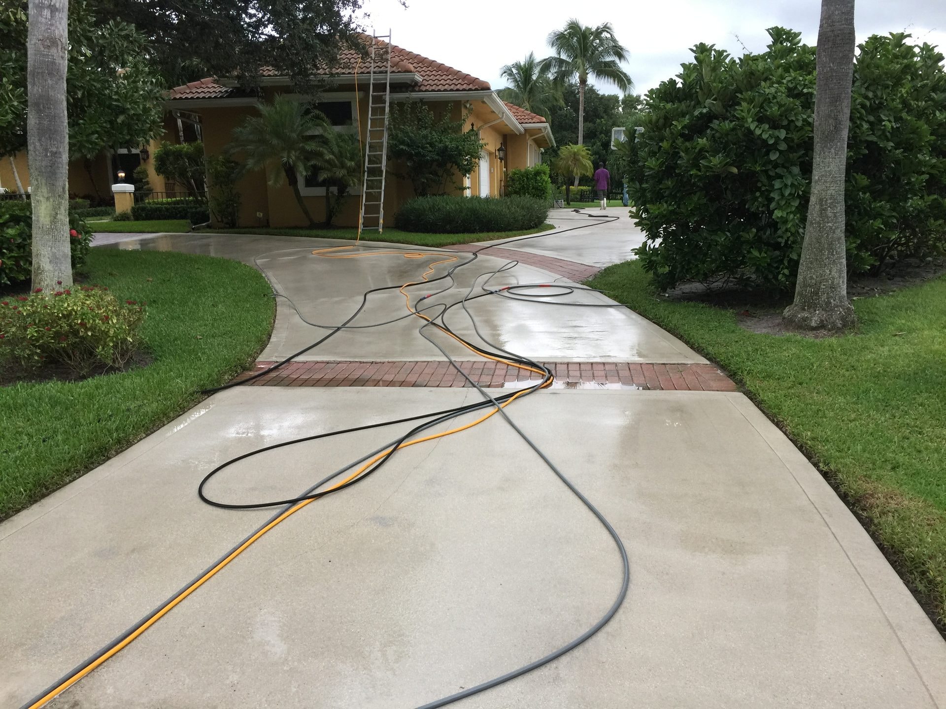After: The same concrete driveway after pressure washing with the cleaned surface visible, Palm Beach Gardens, FL
