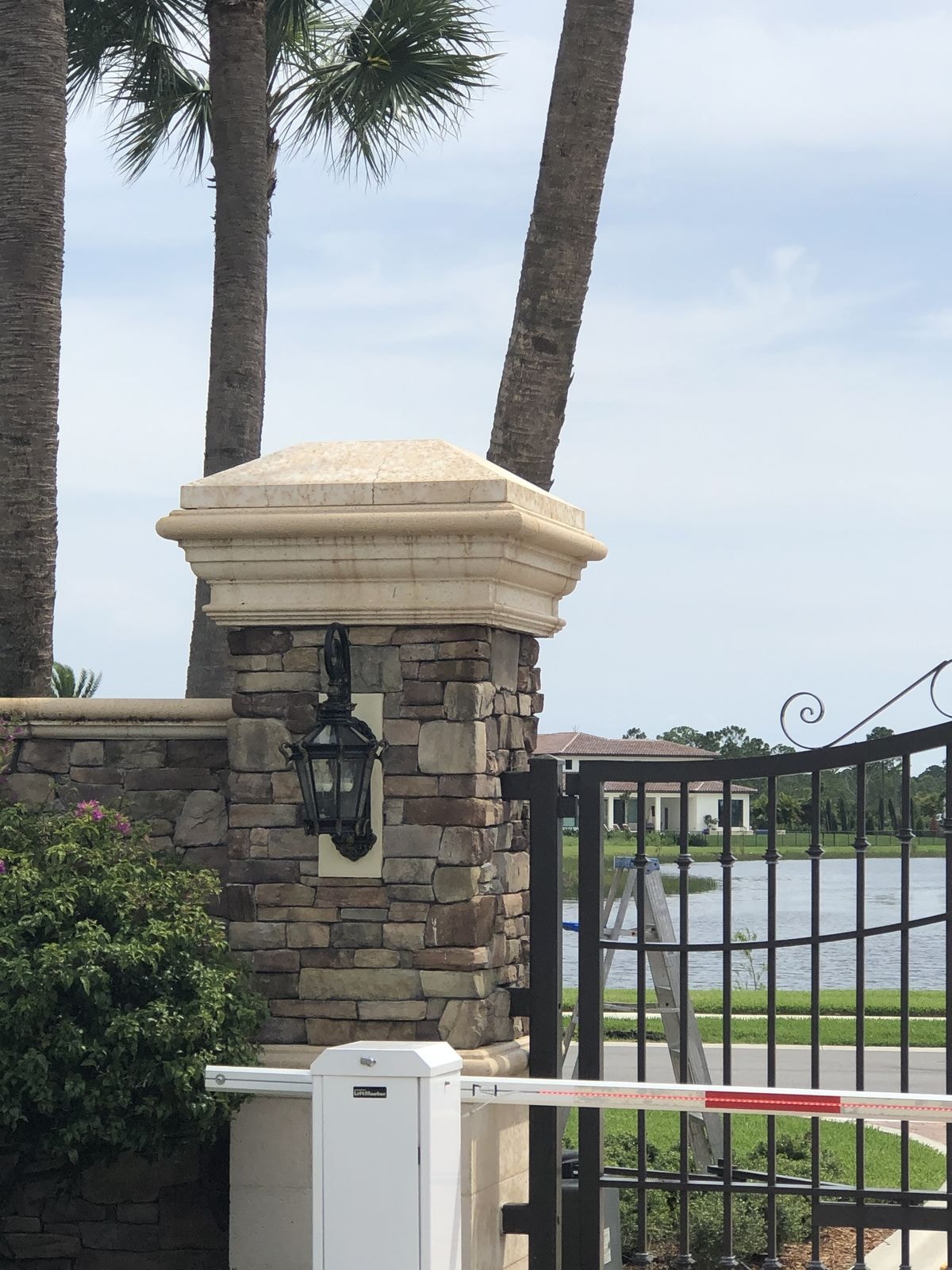 After: Lakefront stone entry column with lantern after cleaning, staining removed from cap, Jupiter, FL