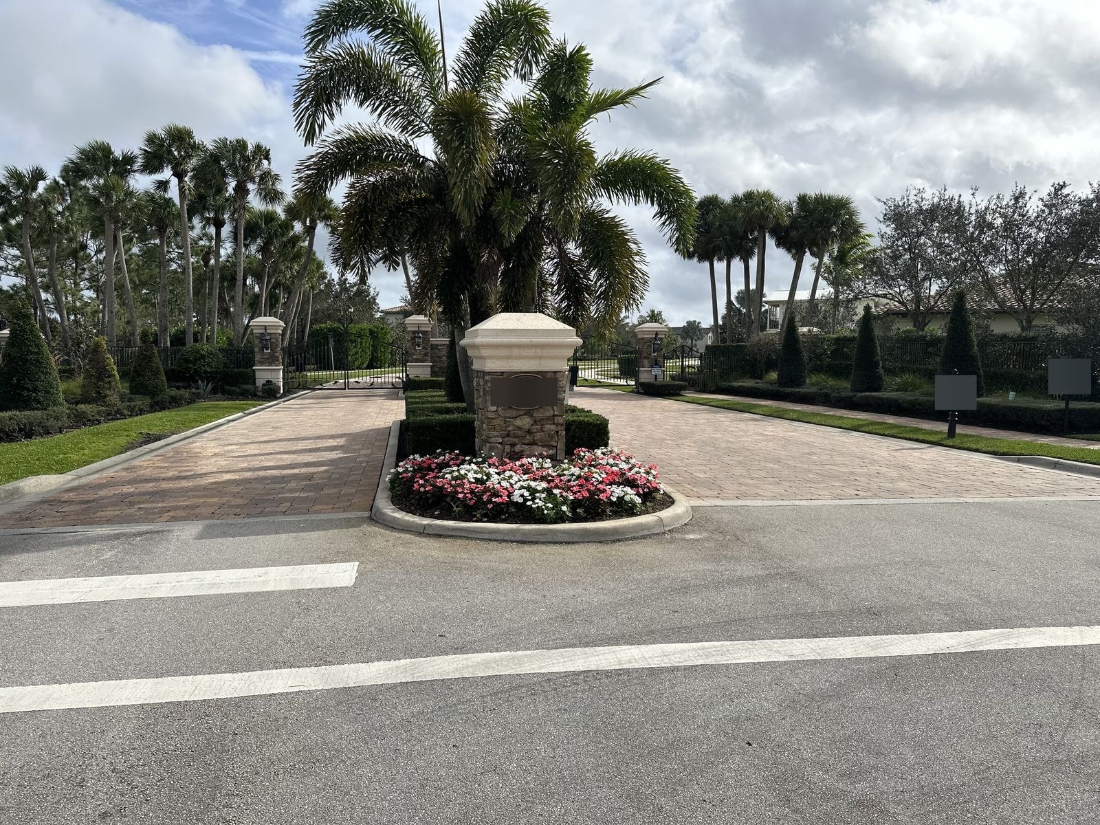 HOA community entry with clean pavers, columns, and landscaping after pressure washing, Jupiter, FL