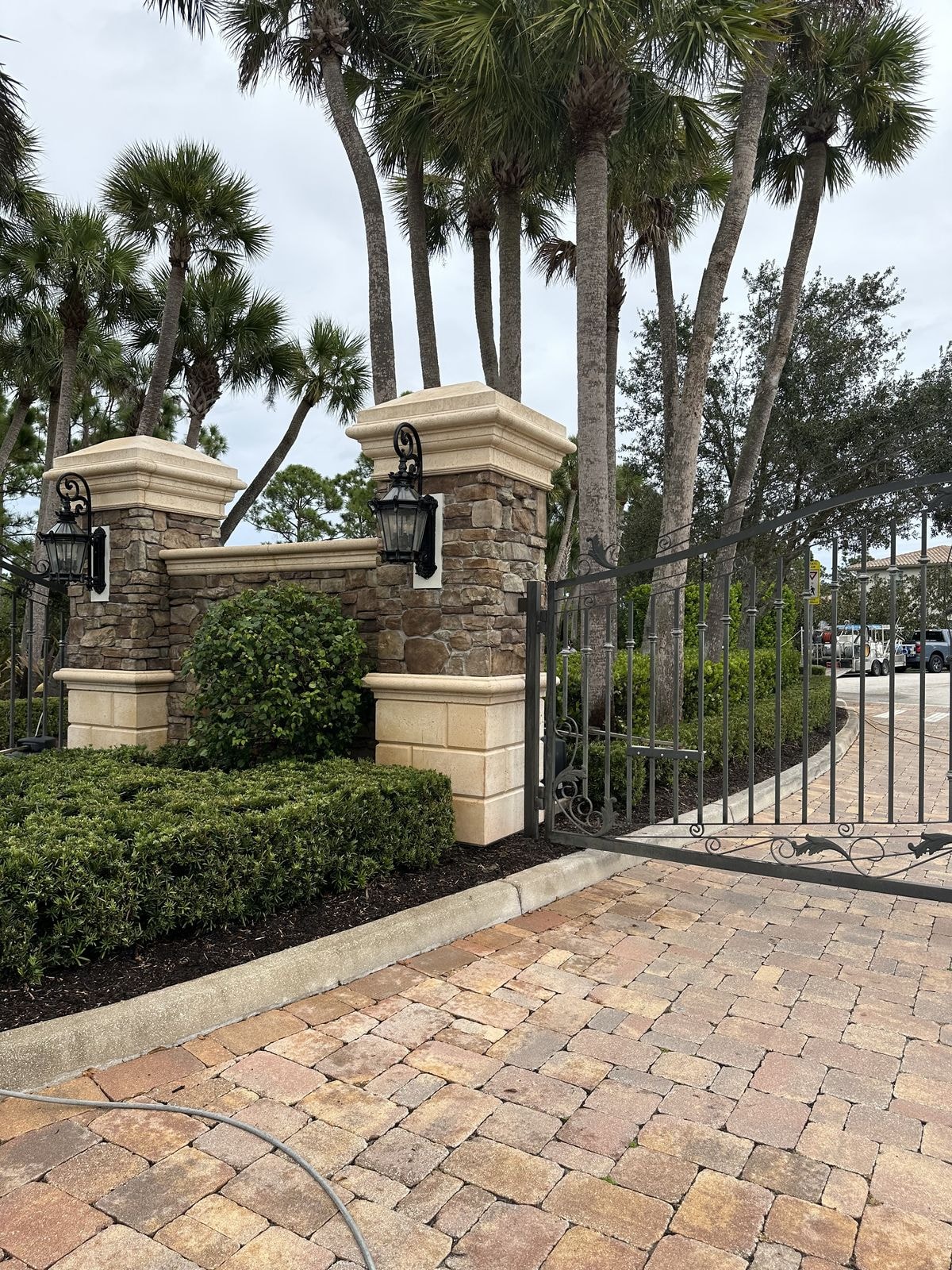 HOA entry gate with stone columns and pavers cleaned and restored, Jupiter, FL