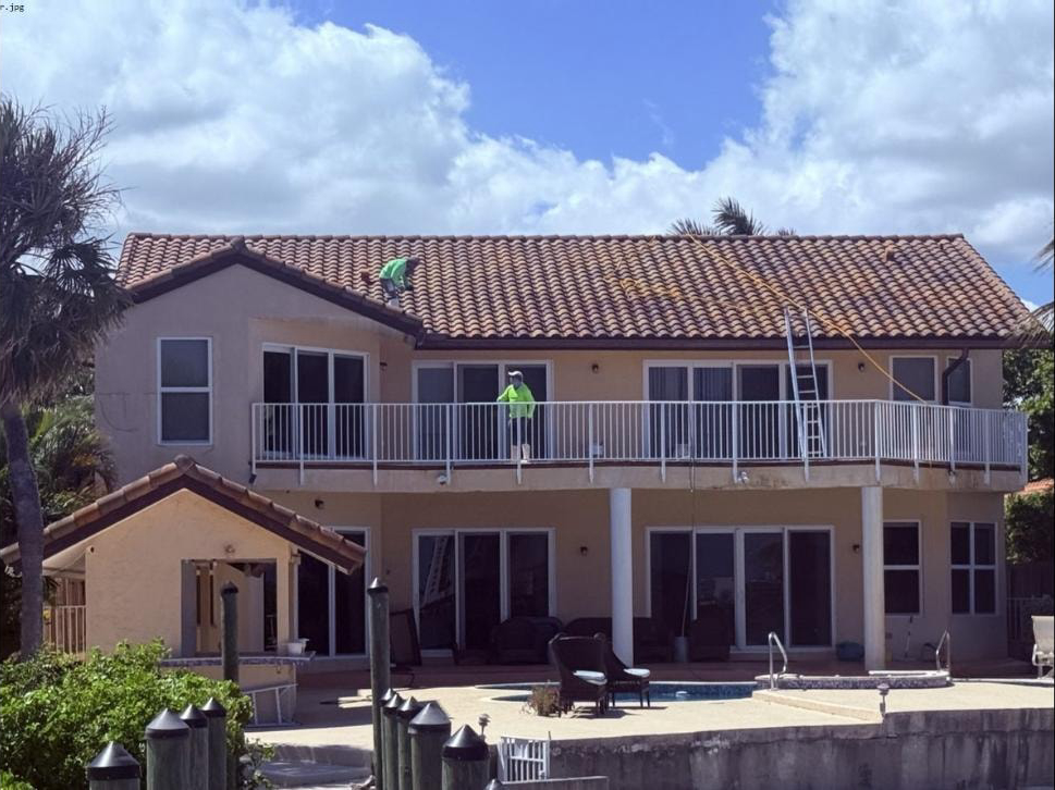 After: Same waterfront home barrel tile roof in Lake Worth Beach, FL after soft-wash cleaning — clean terracotta tiles