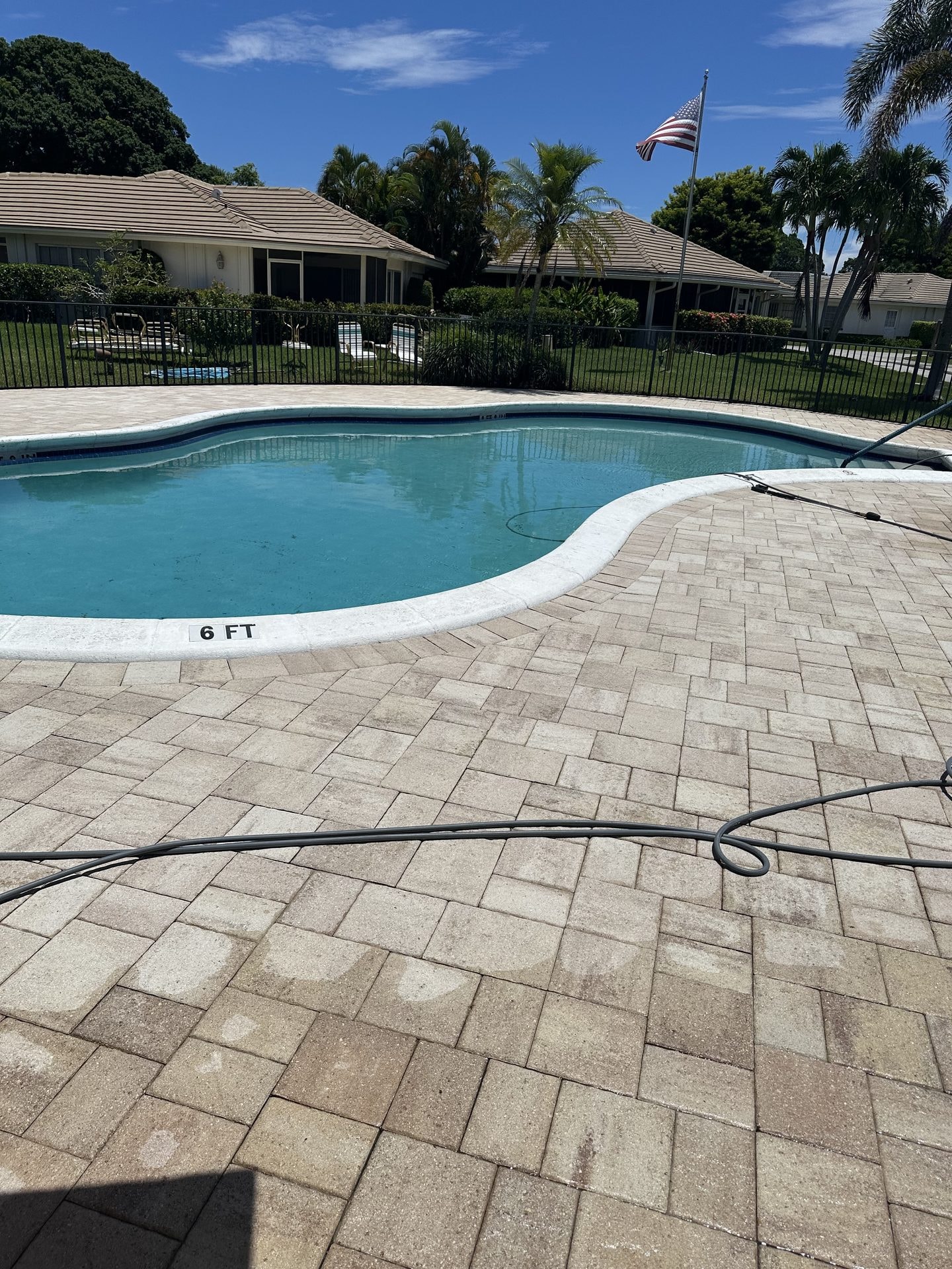 After: The same community pool deck after cleaning with the paver surface restored, Atlantis, FL
