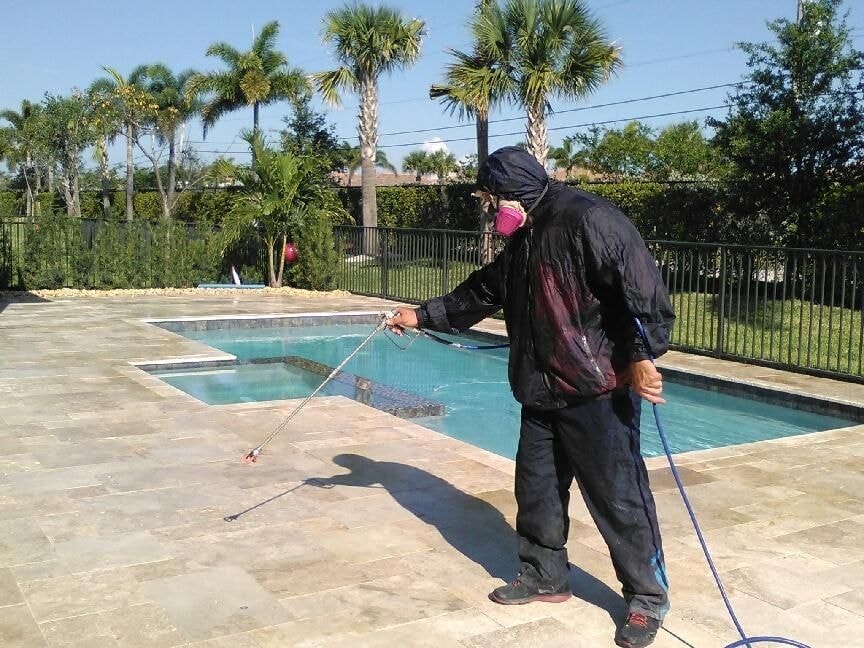 Before: Technician applying sealer to a cleaned travertine pool deck, Wellington, FL