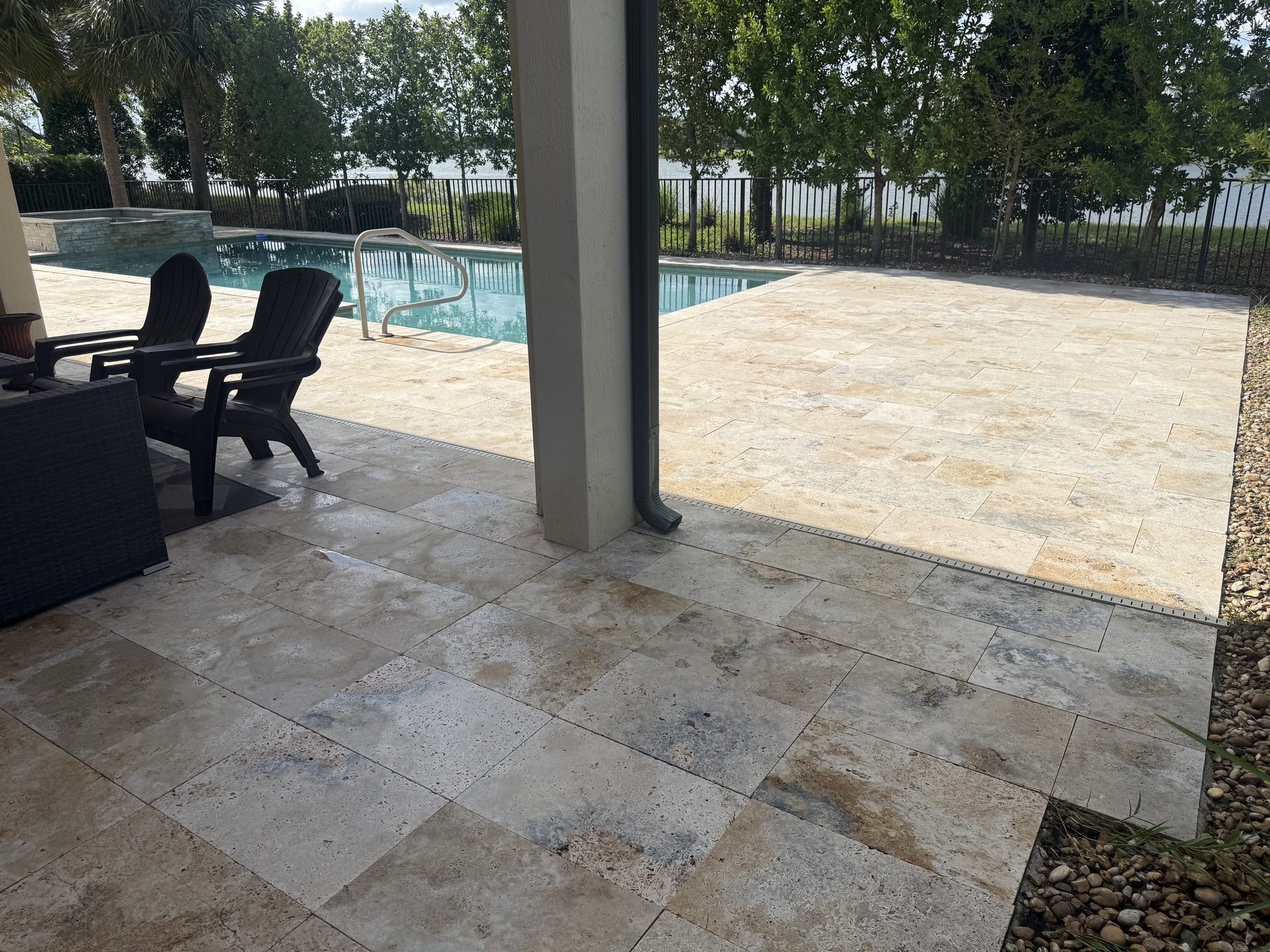 After: The same travertine pool deck after cleaning with the stone restored and the joints clear, lakefront home, Wellington, FL