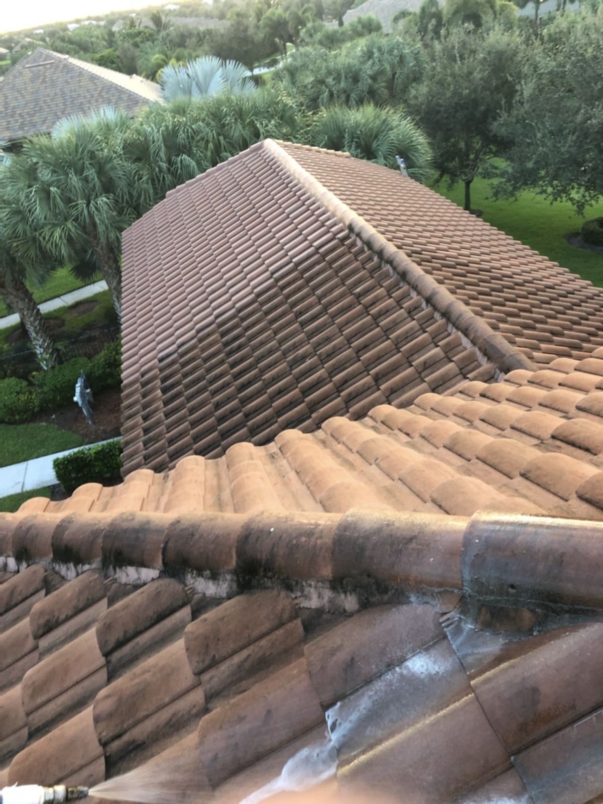 Close view of barrel tile roof with heavy algae streaking and organic staining before soft-wash cleaning, Wellington, FL