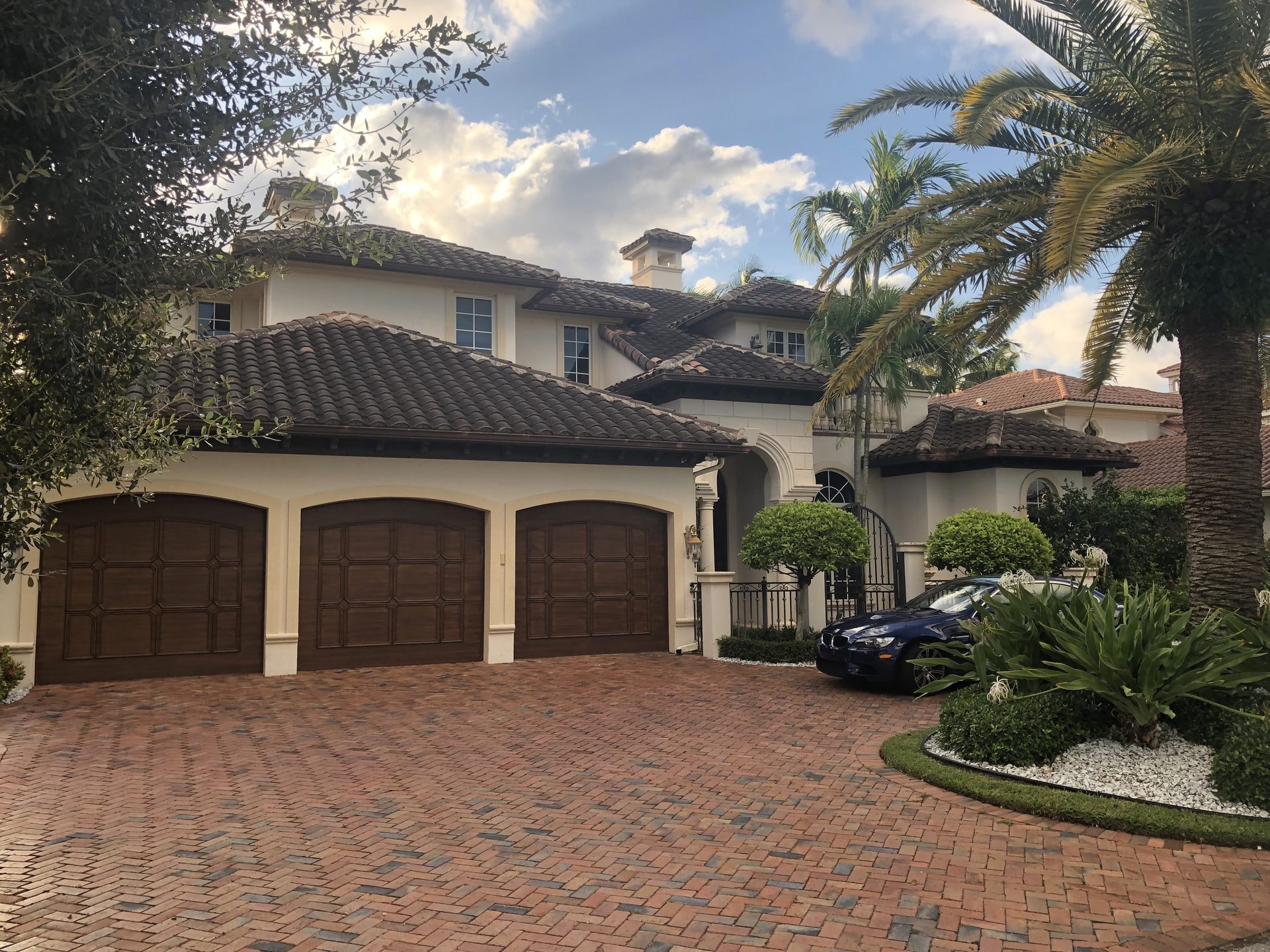 Before: Large estate home with barrel tile roof heavily stained with algae before soft-wash cleaning, Boca Raton, FL