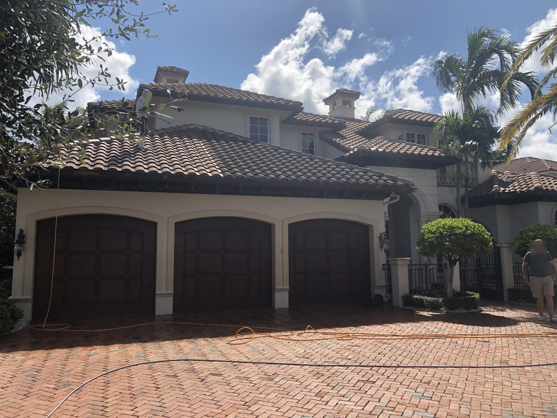 After: The same estate roof mid-clean, with half the garage section left untouched for direct side-by-side comparison, Boca Raton, FL