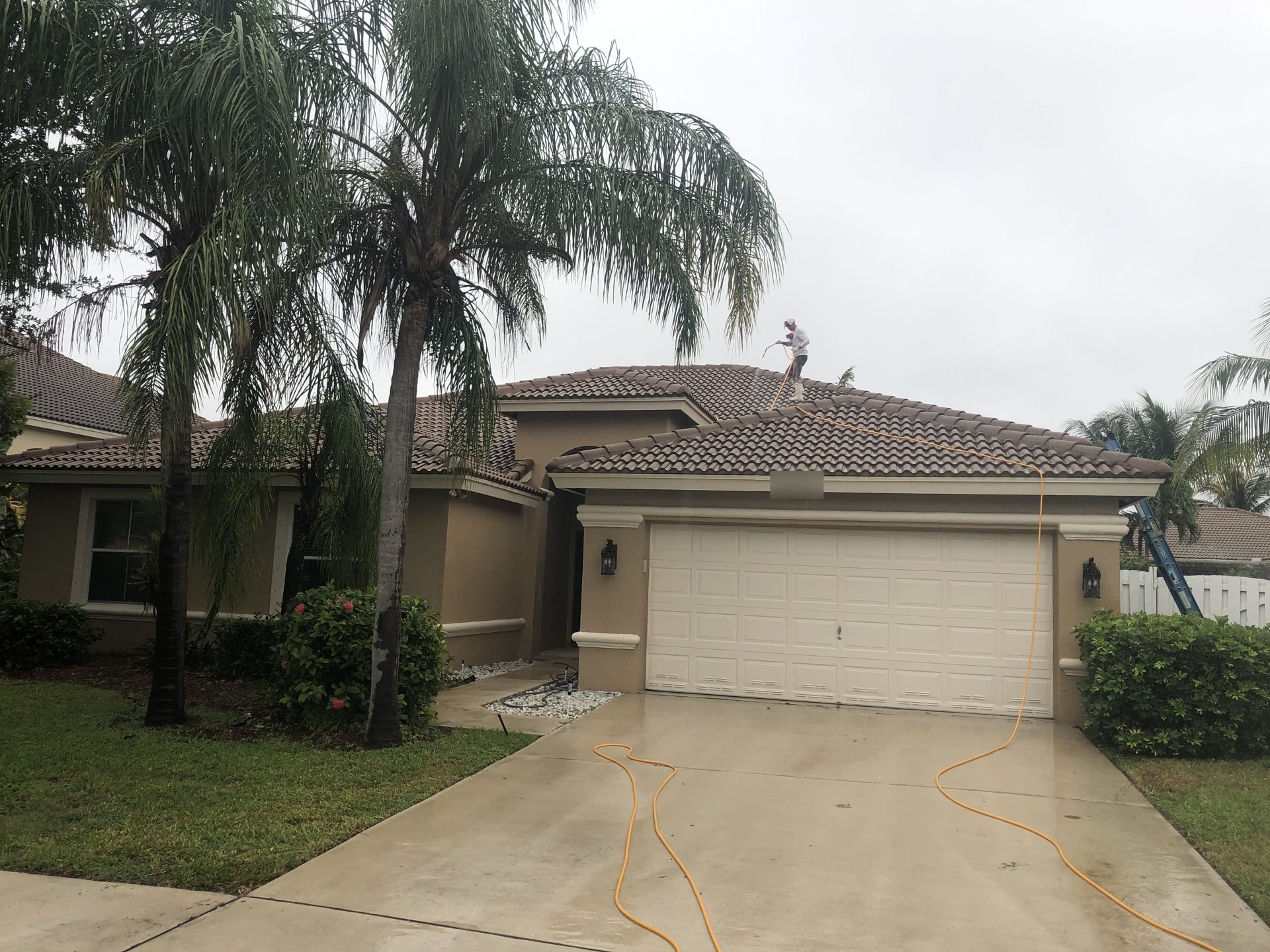 Soft-wash solution being applied to a tile roof, Greenacres, FL