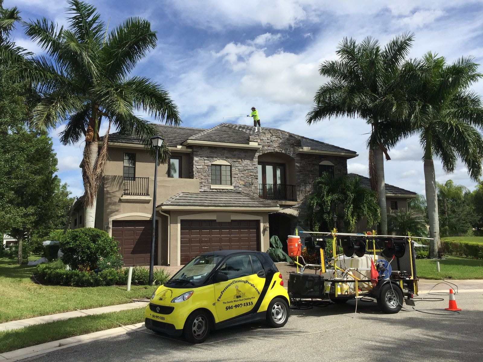 The Pressure Cleaning People service vehicle and soft-wash rig at a Wellington estate with a technician on the roof