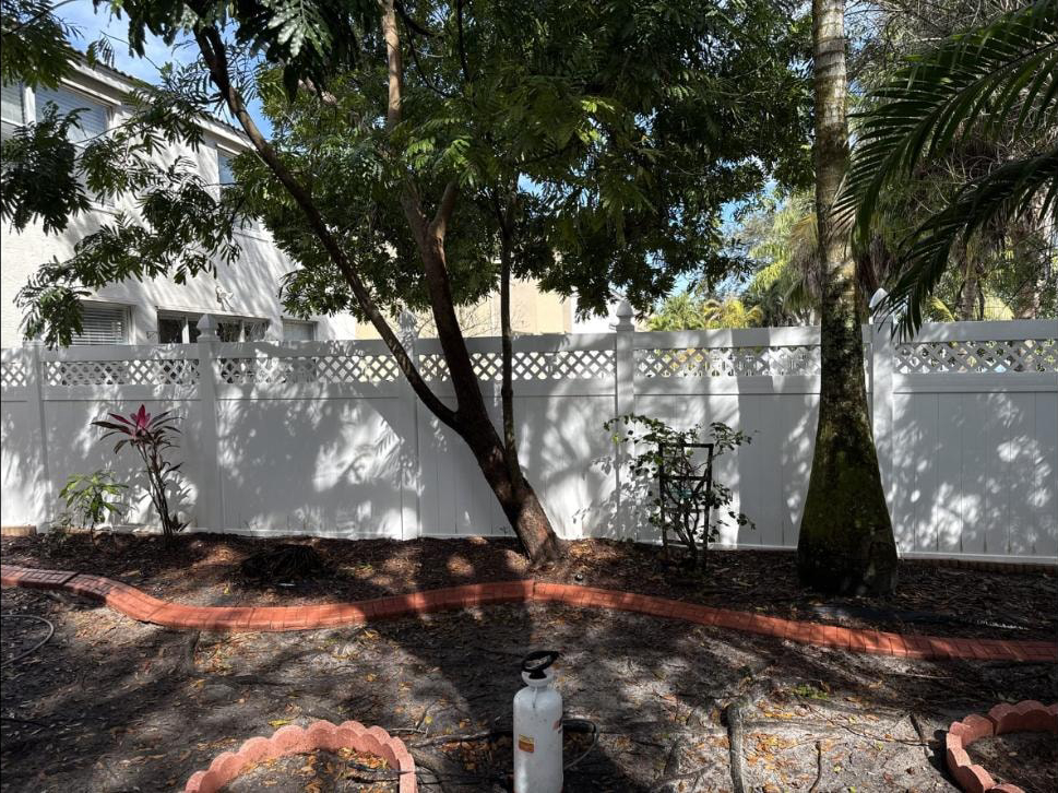 After: Same vinyl fence in Royal Palm Beach, FL after soft-wash cleaning — bright white finish restored
