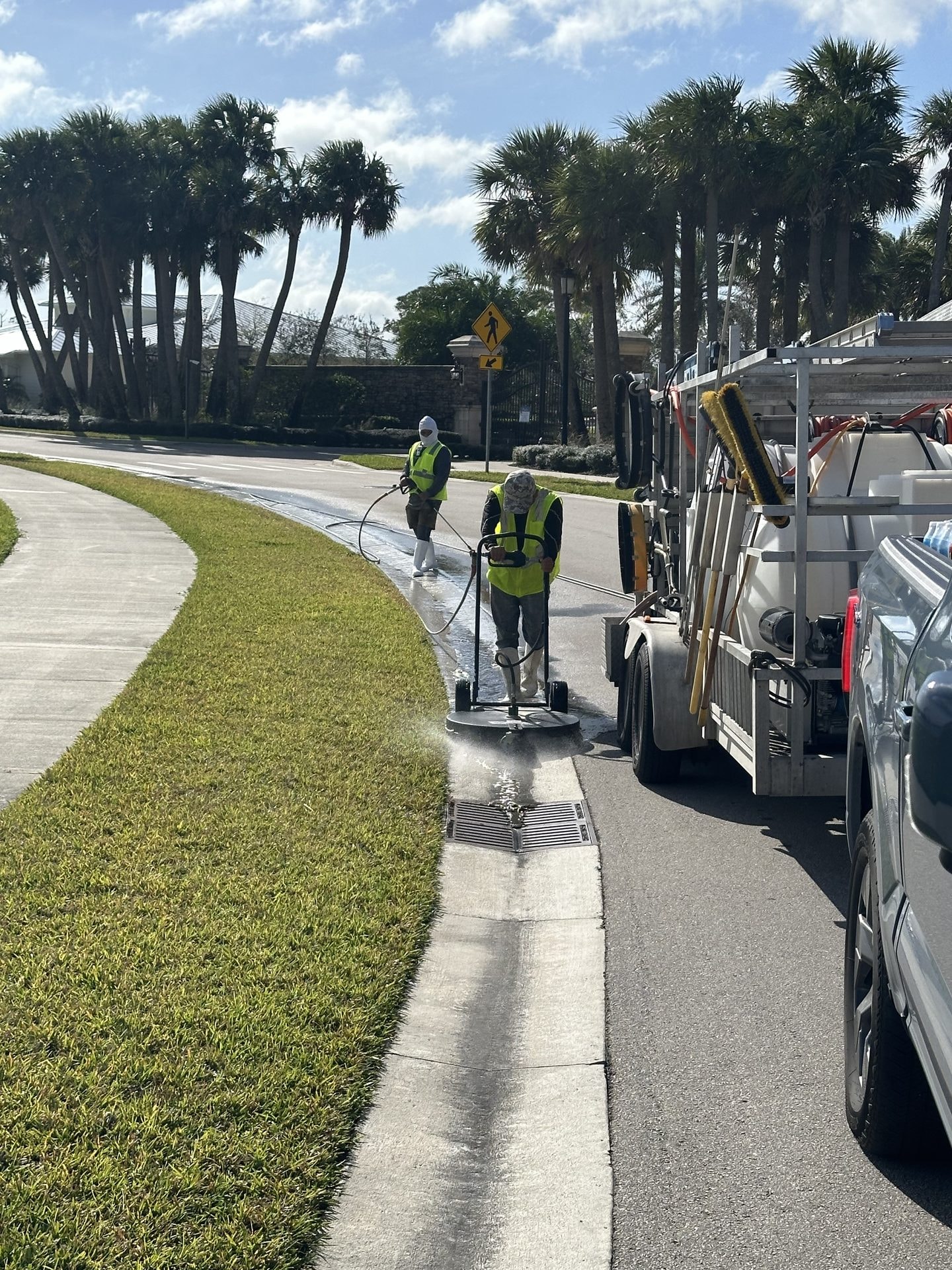 Before: Crew cleaning HOA sidewalk and curb with a surface cleaner and rig on site, Jupiter, FL