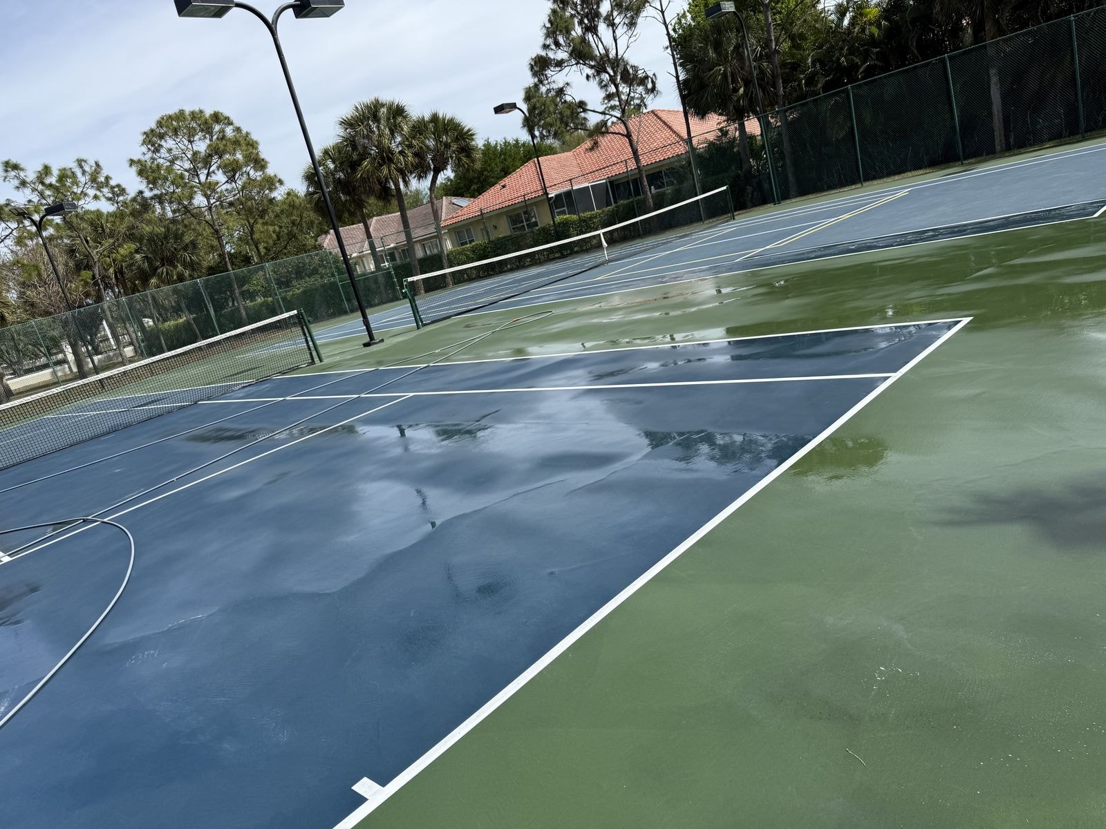 Tennis court after soft-wash cleaning, algae and mold removed in Lake Worth, Florida