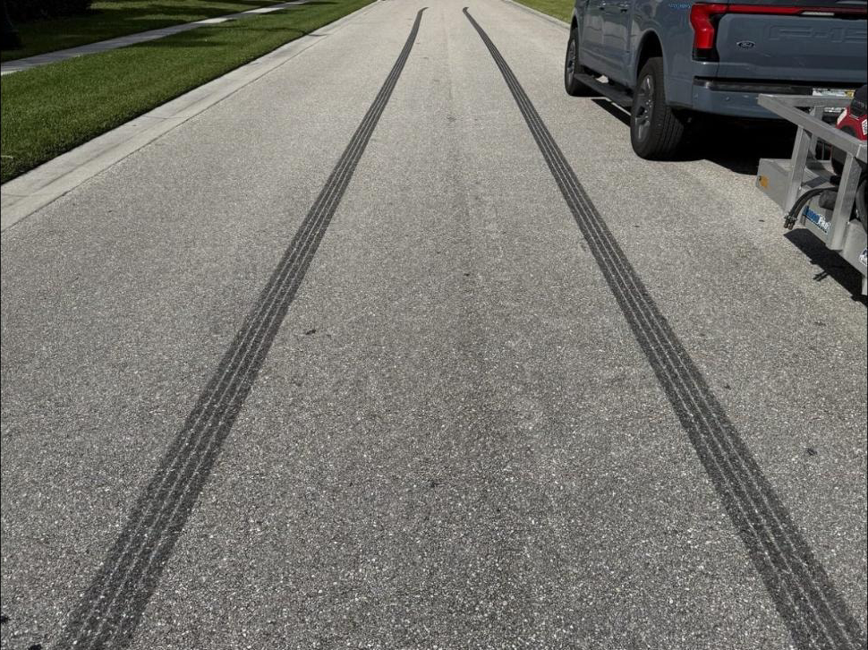 Before: HOA private road in Wellington, FL with black tire skid marks before pressure washing
