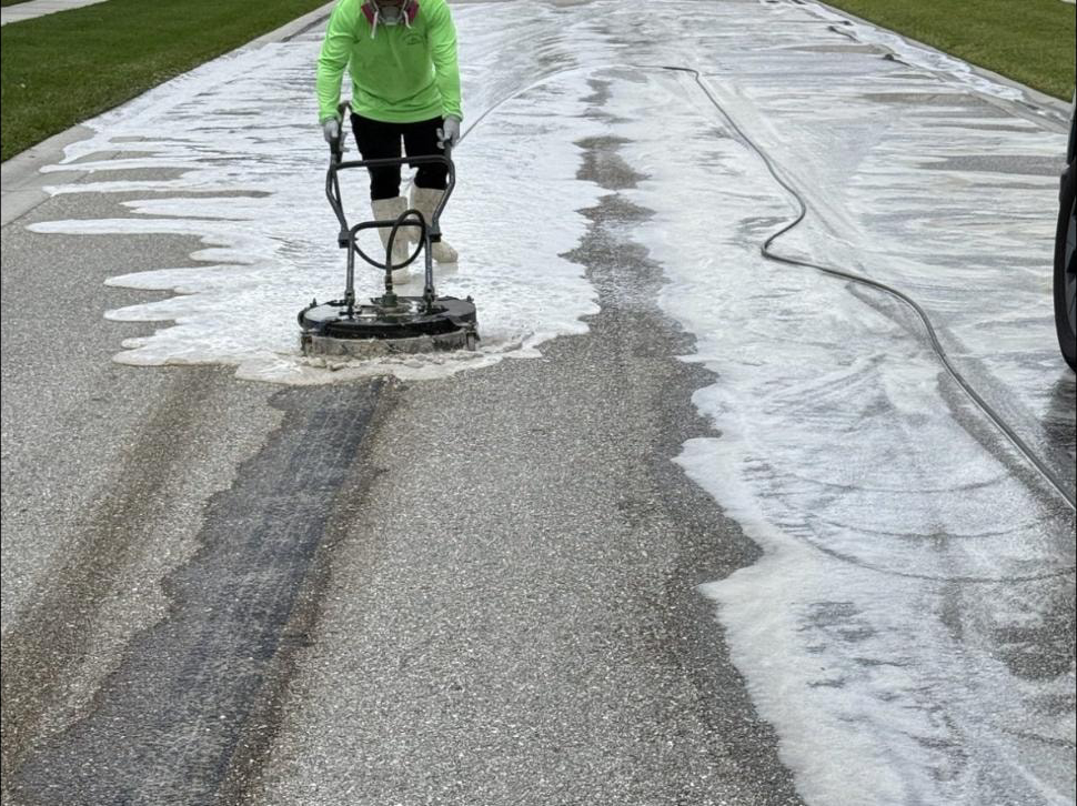After: Technician running surface cleaner on HOA private road in Wellington, FL — foam and clean strip visible